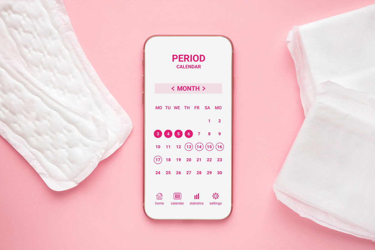Mobile application calendar of the menstrual cycle, daily female pads and hormonal contraceptive pills isolated on a pink background. Design of female menstrual cycle calendar app